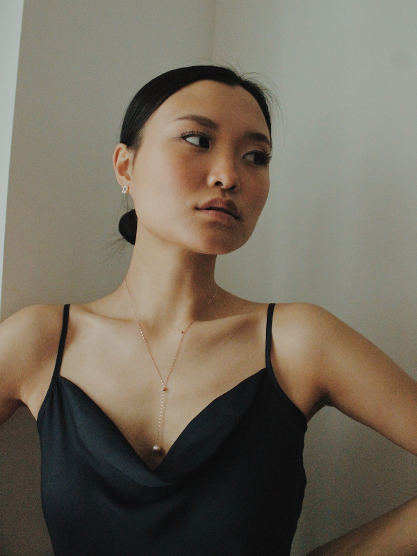 A woman in a sleek black dress, wearing a stylish Zales necklace.