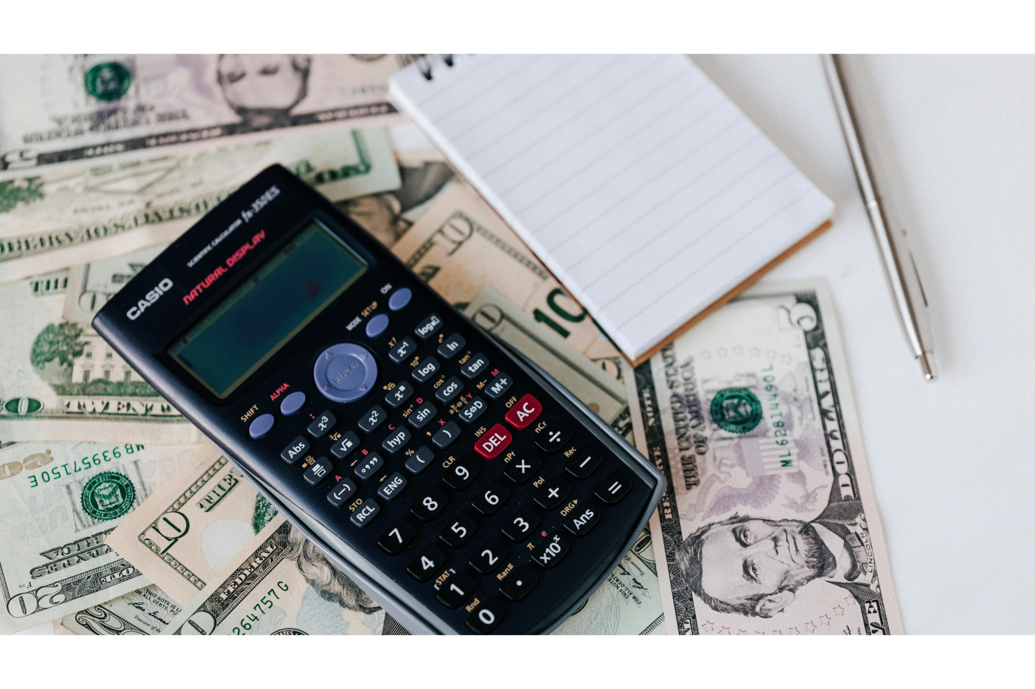 A calculator and notepad placed over a spread of cash, symbolizing the superior ROI and cost-effectiveness of partnering with nano-influencers. The scene represents the meticulous financial analysis used to justify shifting budgets toward smaller, high-engagement creators